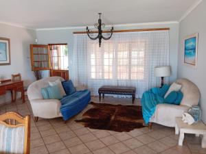 a living room with two chairs and a couch at Galene Guest House in Port Shepstone