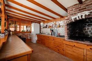a kitchen with wooden cabinets and a brick wall at Paradise Nest in Ohrid