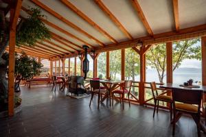 a dining room with tables and chairs and windows at Paradise Nest in Ohrid +99 photos