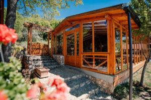 a wooden greenhouse in a garden with flowers at Paradise Nest in Ohrid