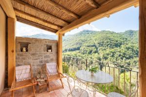 a balcony with a table and chairs and mountains at Apricus Locanda Boutique Hotel in Apricale