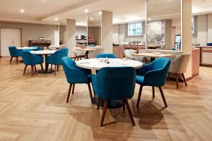 a dining room with tables and blue chairs at Harvey Spa Hotel in Františkovy Lázně