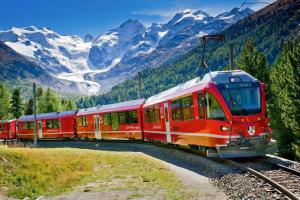 a red train on the tracks in the mountains at Relais Merizzi in Tirano