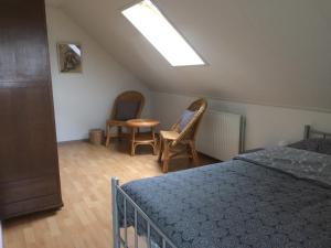 a bedroom with a bed and two chairs and a skylight at B&B op Wijngoed Havelte in Havelte