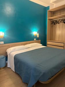 a blue bedroom with a bed and a blue wall at Hotel Sylva in Cattolica