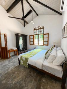 a bedroom with a large bed and a window at The Surveyor's Bungalow in Udugampola