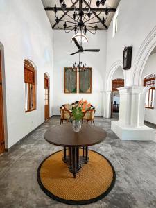 a room with a table with a vase of flowers on it at The Surveyor's Bungalow in Udugampola
