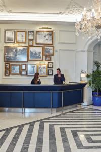 two people sitting at a desk in a lobby at Reid's Palace, A Belmond Hotel, Madeira in Funchal +164 photos