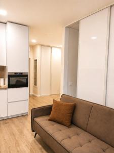 a living room with a couch and a kitchen at Apartment Ainiai in Panevėžys