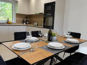 a table with glasses and plates and a bottle of wine at Holiday Home Nada in Tučepi