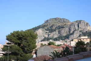 a mountain in the background of a city with houses at BorgoMarino's Room in Cefalù