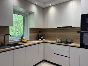 a kitchen with white cabinets and a window at Holiday Home Nada in Tučepi