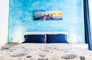 a bedroom with a bed with a painting on the wall at BorgoMarino's Room in Cefalù