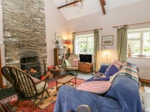 a living room with a couch and a fireplace at Tyn Y Fron in Llanrhystyd