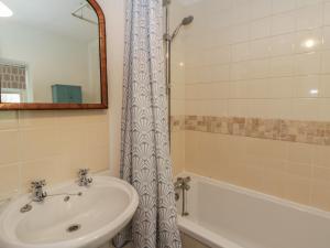 a bathroom with a sink and a bath tub at Tyn Y Fron in Llanrhystyd +24 photos