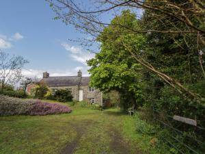 an old stone house with a garden in front of it at Tyn Y Fron in Llanrhystyd