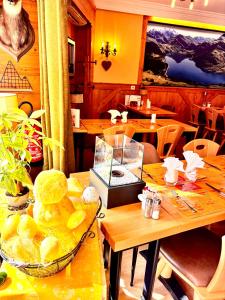 a dining room with tables and chairs with a bowl of food at Hôtel du Grand-Mont in Beaufort