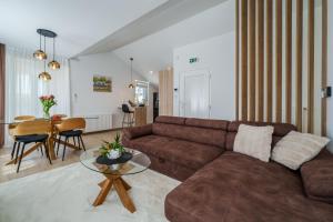 a living room with a brown couch and a table at Apartments Barbara Kraljevica in Kraljevica