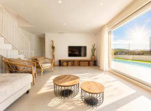 a living room with a couch and tables and a tv at Naramia Sagaro Villa - with Pool-garden-10 Pax in S'agaro