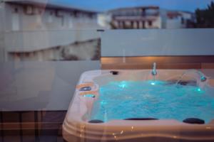 a bath tub with a water fountain in it at Old Cinema Suites - Stylishly Decorated Retreat with Pool or Jacuzzi by the Sea in the Heart of Laganas Βy Villa Mana Gers in Laganas