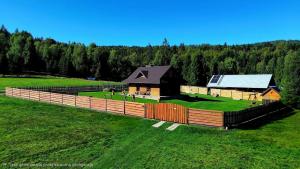 a house in a field with a fence at Dom na Berkówkach pod Barnią Górą in Kamesznica