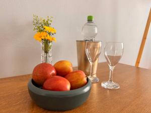 a bowl of fruit on a table with two wine glasses at Fuchsbau Komfort Zimmer in Nordhausen