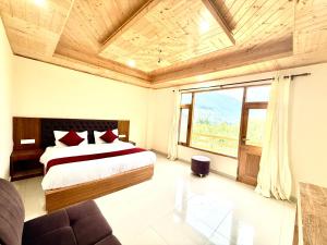 a bedroom with a bed and a large window at The Cow Boy Manali in Manāli +2 photos