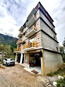 a house with a car parked in front of it at The Cow Boy Manali in Manāli