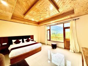 a bedroom with a bed and a large window at The Cow Boy Manali in Manāli