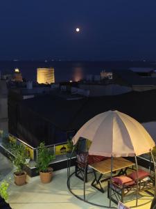 a table and chairs under an umbrella on a roof at Atropat Old City Hotel in Baku