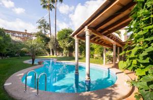 a swimming pool under a pavilion in a yard at Son Sant Jordi Boutique House in Pollença