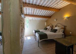 a bedroom with two beds in a room at Hôtel Le Rocher des Abeilles in Saint-Martin-de-Castillon