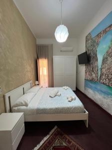 a bedroom with a bed and a painting on the wall at B&b I 7 MARI in Salerno