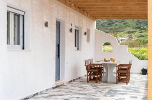 a patio with a table and chairs on a house at Vigla's Tiny House - Steps to the Beach in Mikri Vigla