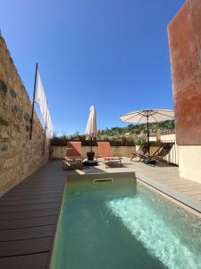 a pool with two chairs and an umbrella on a deck at Tantillo Cinque in Modica
