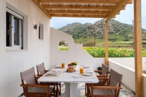 a table and chairs on a patio with a view at Vigla's Tiny House - Steps to the Beach in Mikri Vigla