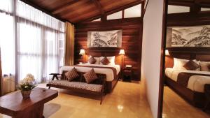 a bedroom with two beds and a chair and a table at DAMAI in Canggu +21 photos