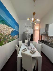 a dining room with a white table and chairs at B&b I 7 MARI in Salerno