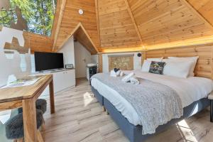 a bedroom with a large bed and a wooden ceiling at Alpin D'Hôme Hôtel & Spa in Les Orres