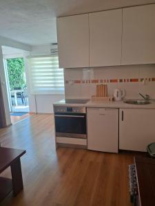 a kitchen with white appliances and a wooden floor at SkyLine apartments in Mostar