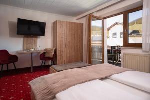 a hotel room with a bed and a television at Bayerische Gastwirtschaft Dimpfl-Stadl in Lam +42 photos