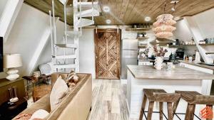 a kitchen and living room with a staircase and a table at Serene Mountain Waterfront A-Frame Cabin in Robbinsville