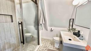 a bathroom with a shower and a toilet and a sink at Serene Mountain Waterfront A-Frame Cabin in Robbinsville +9 photos