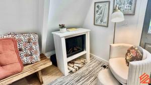 a living room with a fireplace and a chair at Serene Mountain Waterfront A-Frame Cabin in Robbinsville
