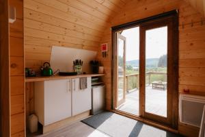 a kitchen with a large glass door leading to a deck at Reservoir View Micro Cabin in Dol-y-gaer Station