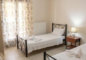 a bedroom with two beds and a table and a window at Villa Maria in Ierissos