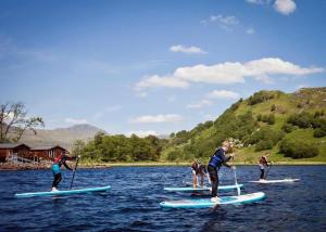 a group of people on paddle boards in the water at Ardlui Holiday Park in Arrochar