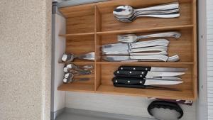 a wooden cabinet with utensils in a kitchen at Struga Alpha House in Struga +16 photos