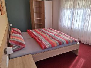 a bed with a colorful blanket on it in a room at Pension Hösl in Mitterteich