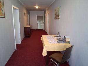 a room with a table and chairs and a hallway at Pension Hösl in Mitterteich